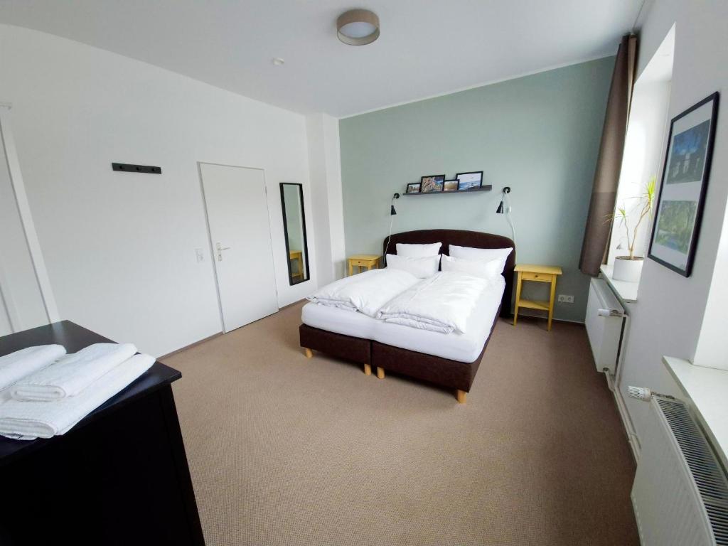 a bedroom with a bed with white sheets and pillows at Gästehaus bed & kitchen in Schleswig
