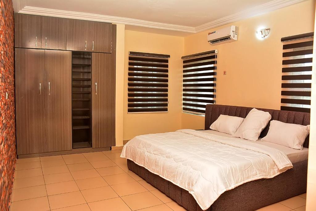 a bedroom with a large bed with white sheets at 21 Suites & Apartments in Mama