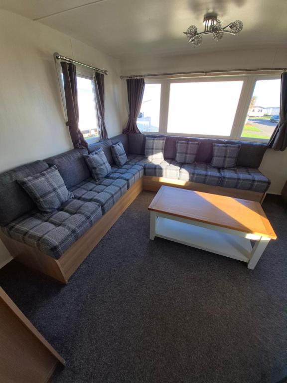 a living room with a couch and a coffee table at Lyon's Robin Hood Rhyl 8 Berth Caravan in Rhyl