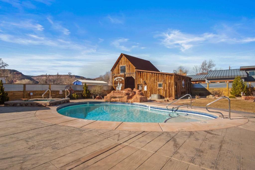 a pool in front of a barn with a house at Timber & Tin B 1Bed 1Bath w Pool & Rooftop Deck in Kanab