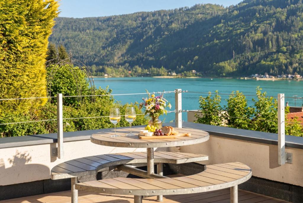 a table on a balcony with a view of a lake at Lake Lodge Ossiacher See in Annenheim