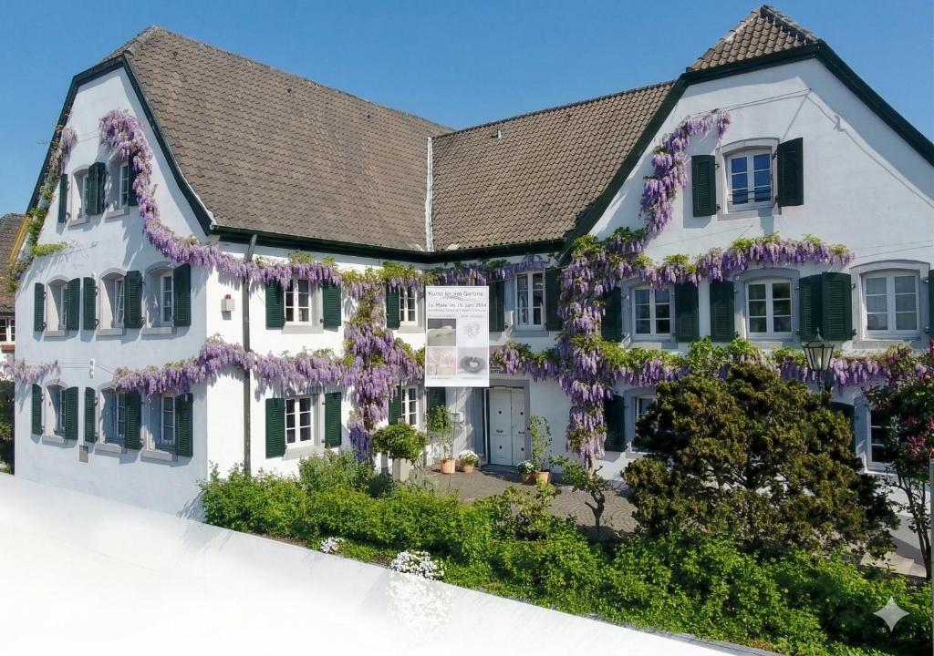 a white house covered in wisteria at Rhein River Guesthouse - direkt am Rhein in Leverkusen