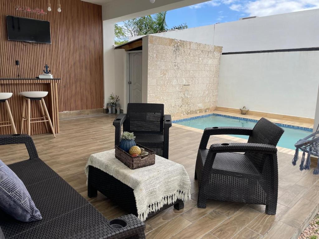 a living room with chairs and a swimming pool at Simon Vip Complete Villa in Punta Cana