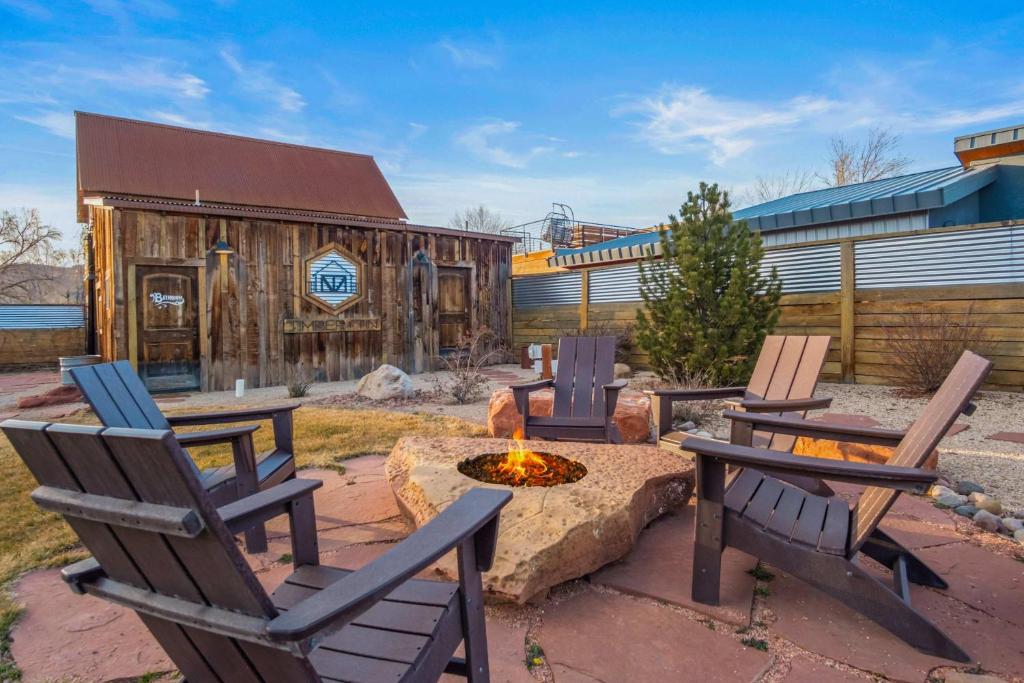 a group of chairs and a fire pit in a yard at Timber & Tin E 2Bed 2Bath w Pool & Rooftop Deck in Kanab
