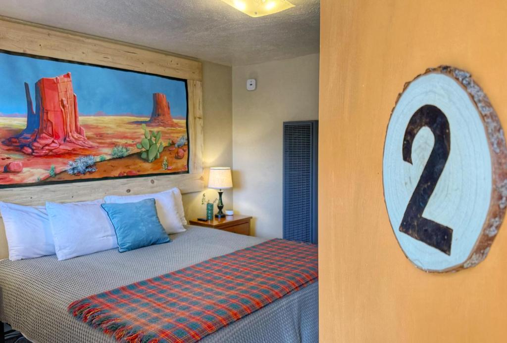 a bedroom with a bed with a painting on the wall at Hózhó King Mokee Shared Kitchen, Pets Ok #2 in Bluff