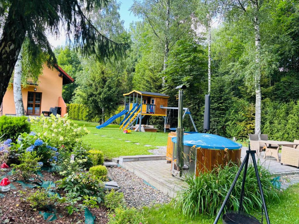 a garden with a playground and a house at Domek nad Wisłą in Ustroń
