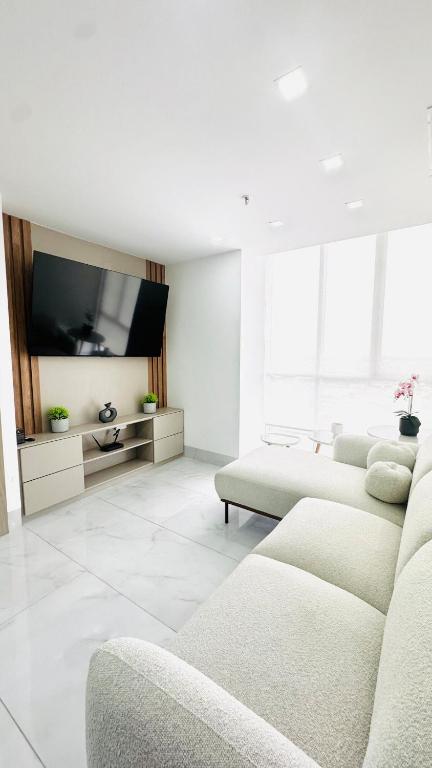 a living room with couches and a flat screen tv at Zen Living Sky Suite in SamborondÃ³n