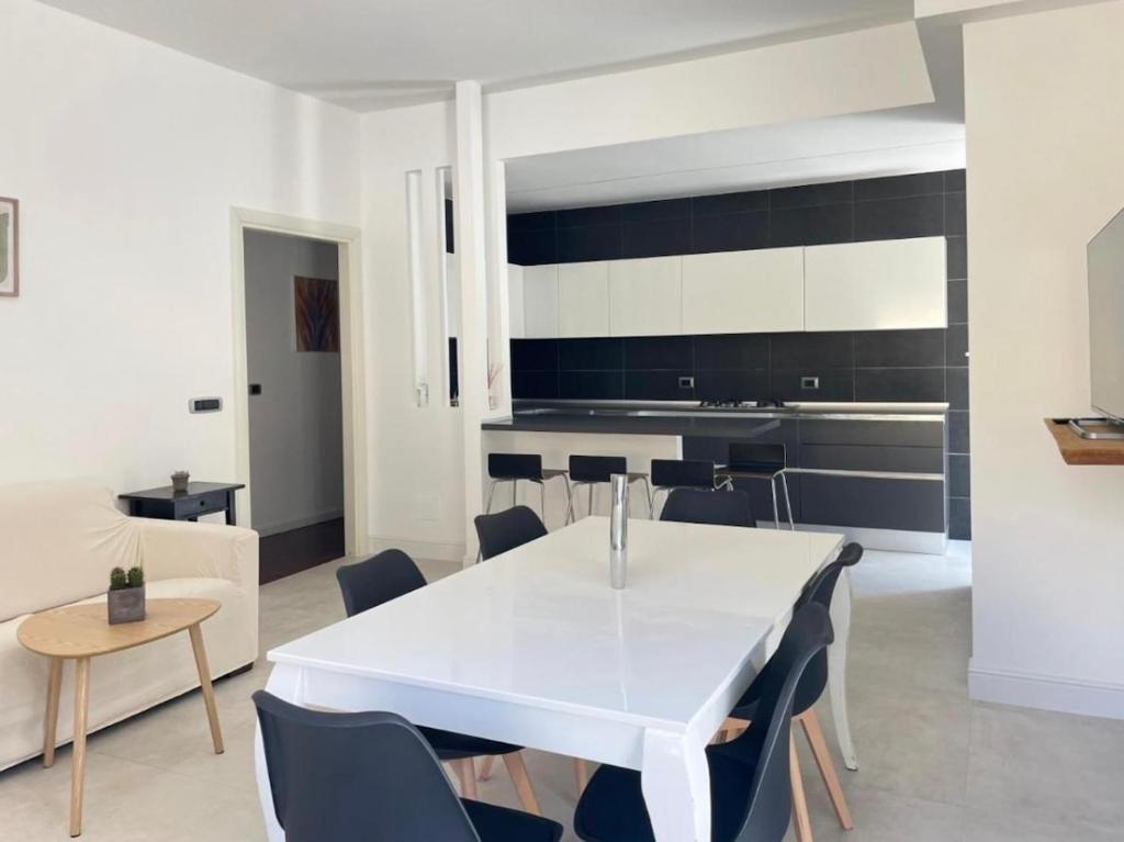 a dining room with a white table and chairs at Anzio lighthouse terrace family-group friendly in Anzio