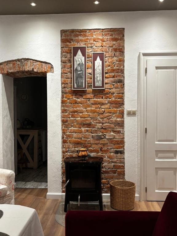 a brick wall with a fireplace in a living room at Petite Charlotte in Tarnów