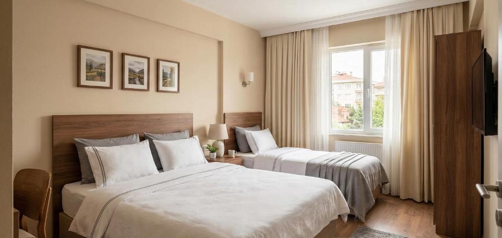 a hotel room with two beds and a window at Levent Hotel in Lara