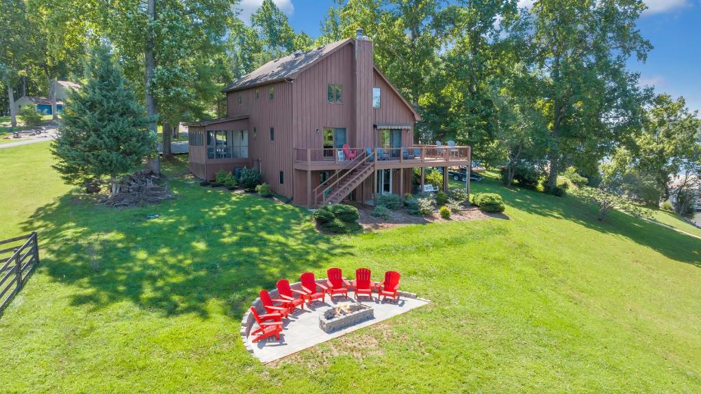 a group of red chairs sitting in front of a house at Pine Knob Point - Lakehouse w/ Private Dock in Moneta