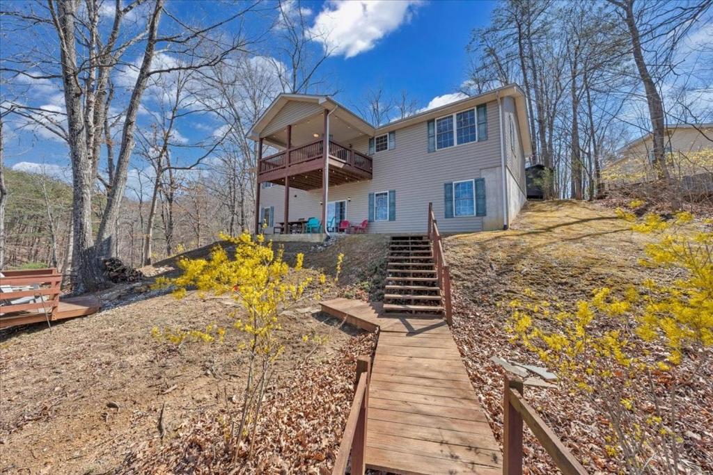 a house with a wooden walkway in front of it at Whisper Haven - Private dock & Pet friendly in Moneta