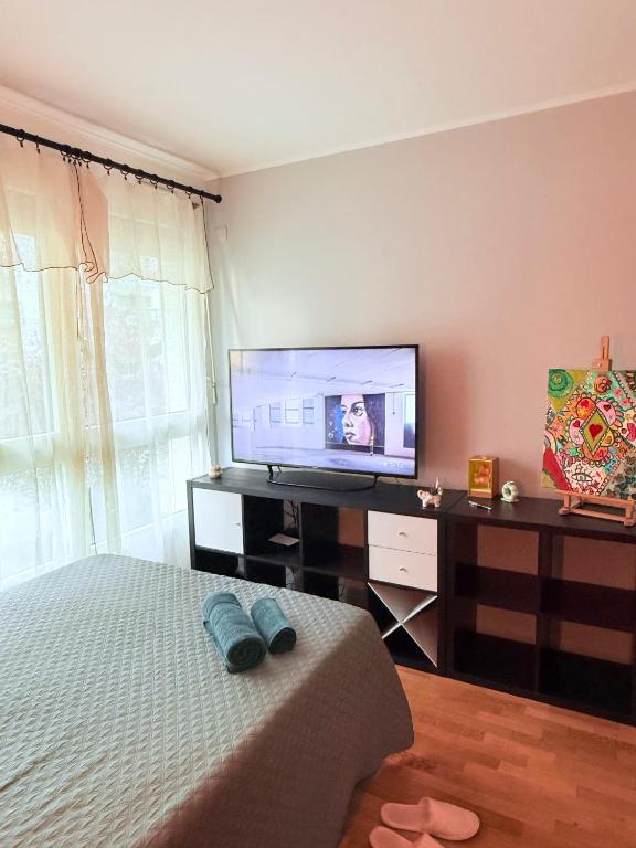 a bedroom with a bed and a flat screen tv at Apparemment agréable in Levallois-Perret