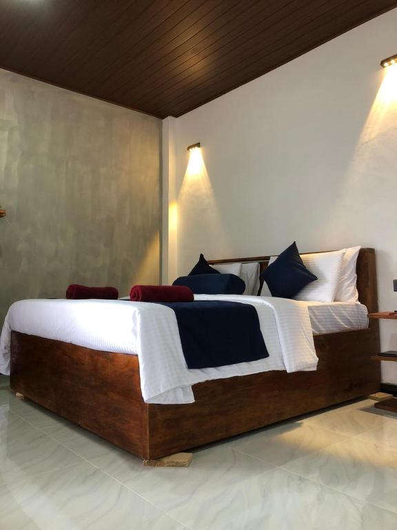 a bedroom with a large bed with blue and white pillows at Ella 96TN Resort in Ella