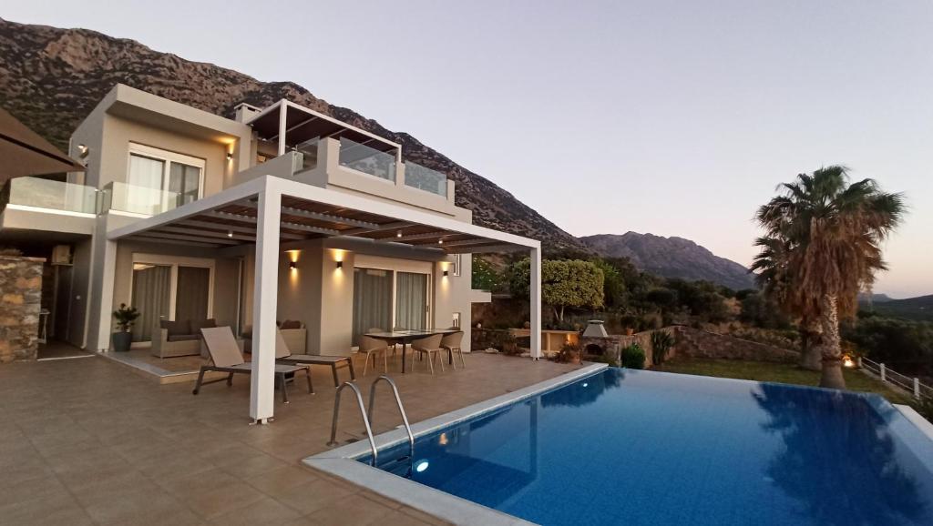 a villa with a swimming pool and a house at Villa Tholos Crete in Kavoúsion