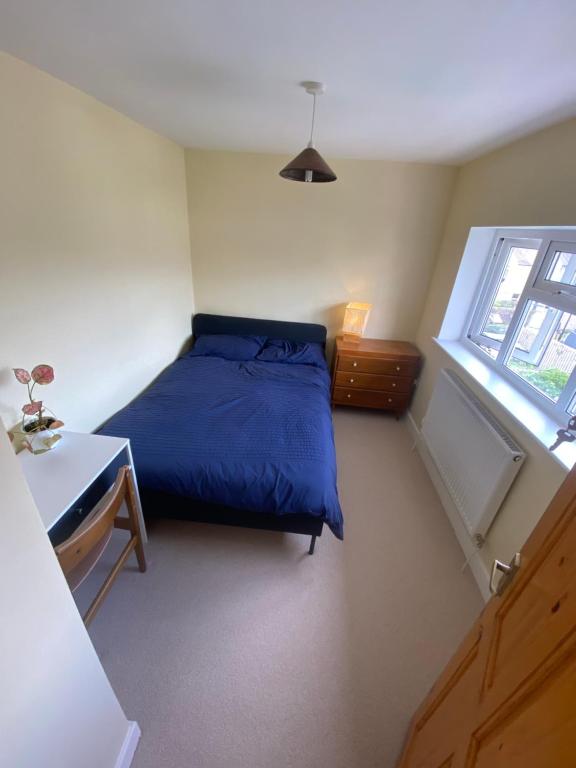 a bedroom with a blue bed and a window at Peaceful Fields in Lancaster