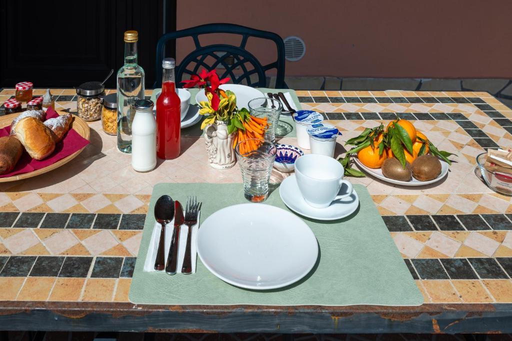 a table with plates and utensils on a table at B&B Med - Finestra sul Mare in Contrada Mastrissa
