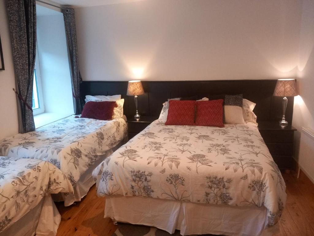 a bedroom with two beds and two lamps at Teach Sile in Kiltimagh