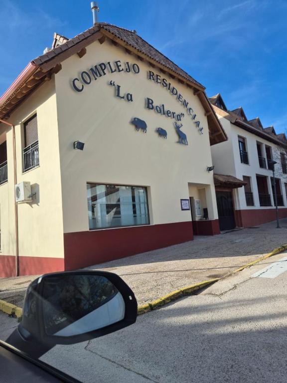 a side view mirror of a car parked in front of a building at El Refugio de la montaña in Arroyo Frio