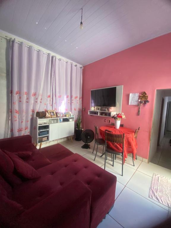 a living room with a red couch and a table at Quarto para o Moto GP in Goiânia