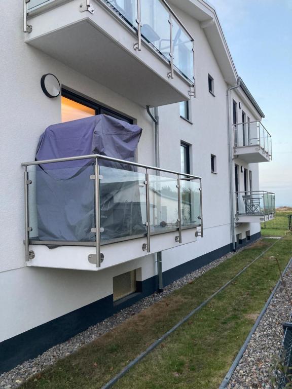 a building with a balcony with a purple tarp on it at Fewo Paul in Glowe