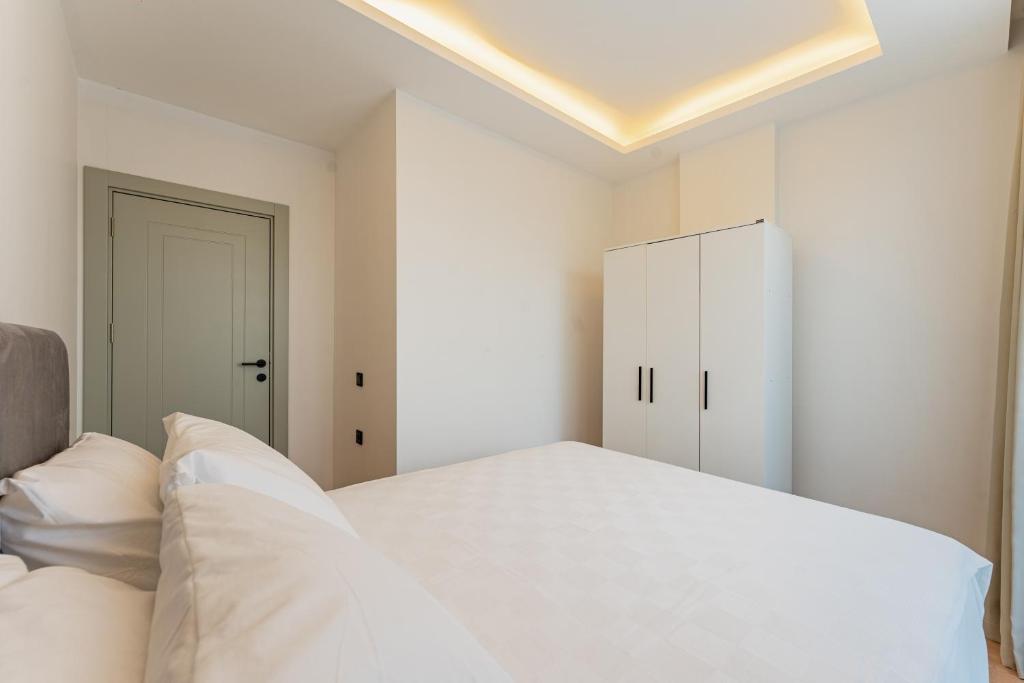 a bedroom with a white bed and a white cabinet at VISTA SERENA Ermenek in Altınkum