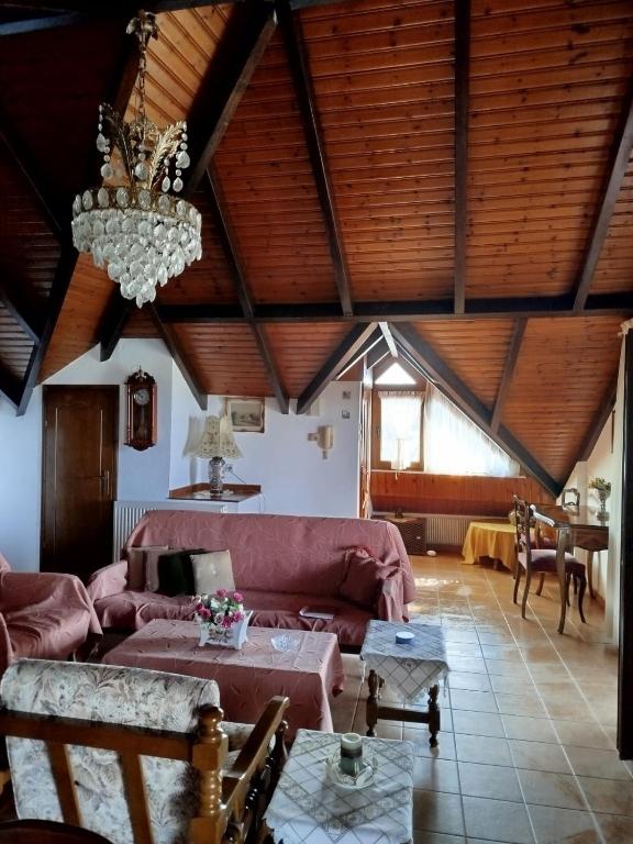 a living room with a couch and a chandelier at Anastasia in Áno Lekhónia