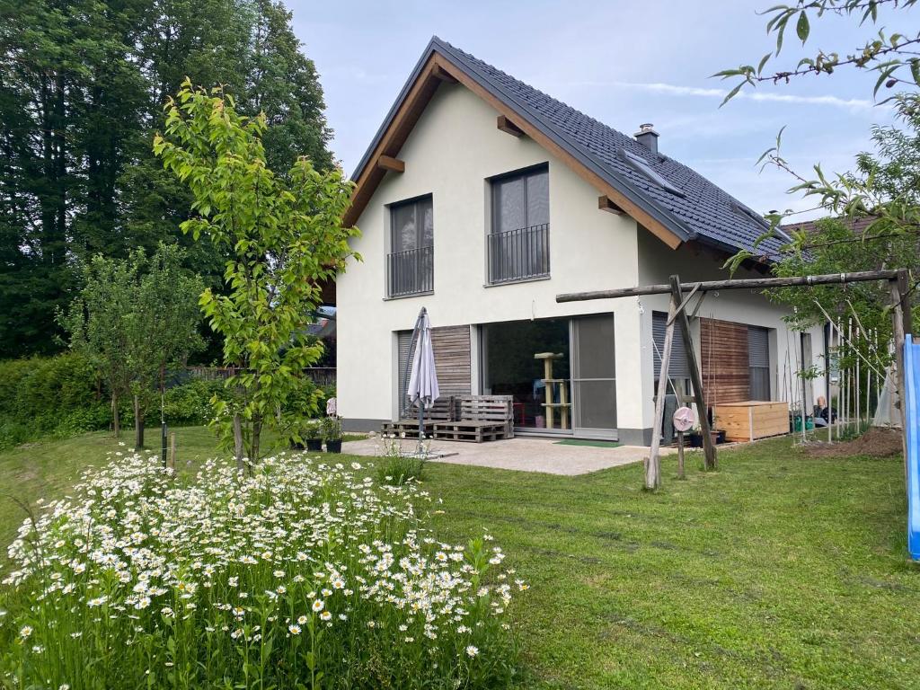 a white house with a yard with white flowers at River & Forest Escape, Private Garden Room near Ljubljana in Preddvor