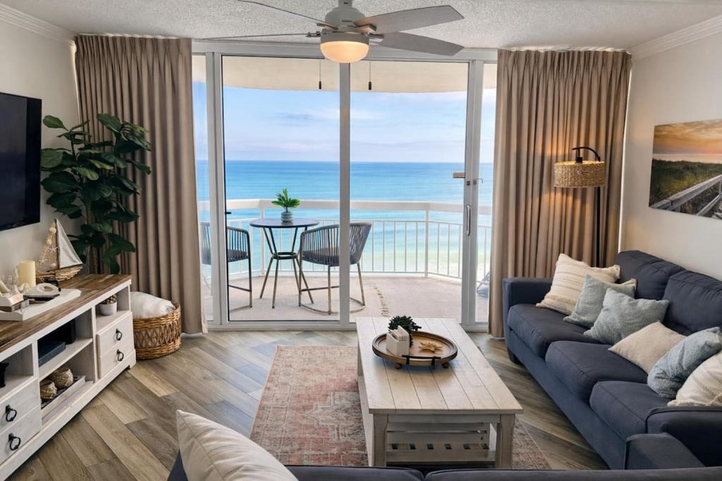a living room with a blue couch and a view of the ocean at Waters Edge in Myrtle Beach