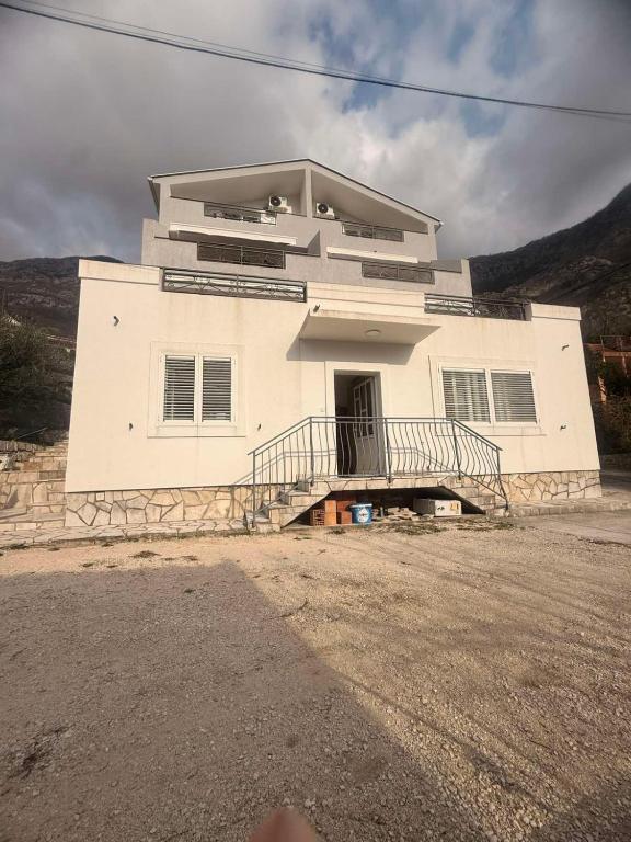 a white house with a staircase in front of it at Apartman Danilo i Filip in Risan