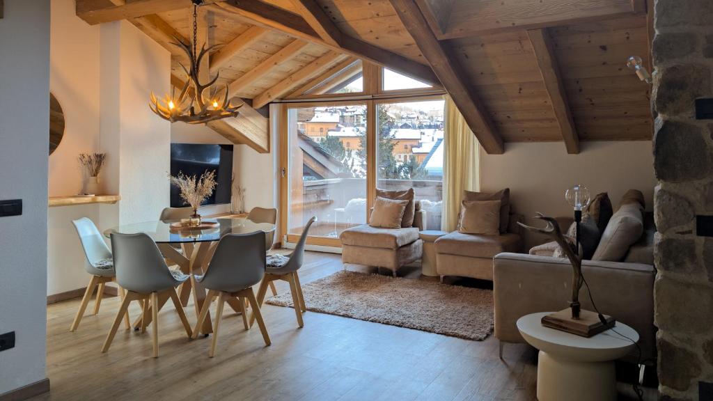 a living room with a table and chairs and a couch at Silva: The Alpine Chalet in Livigno