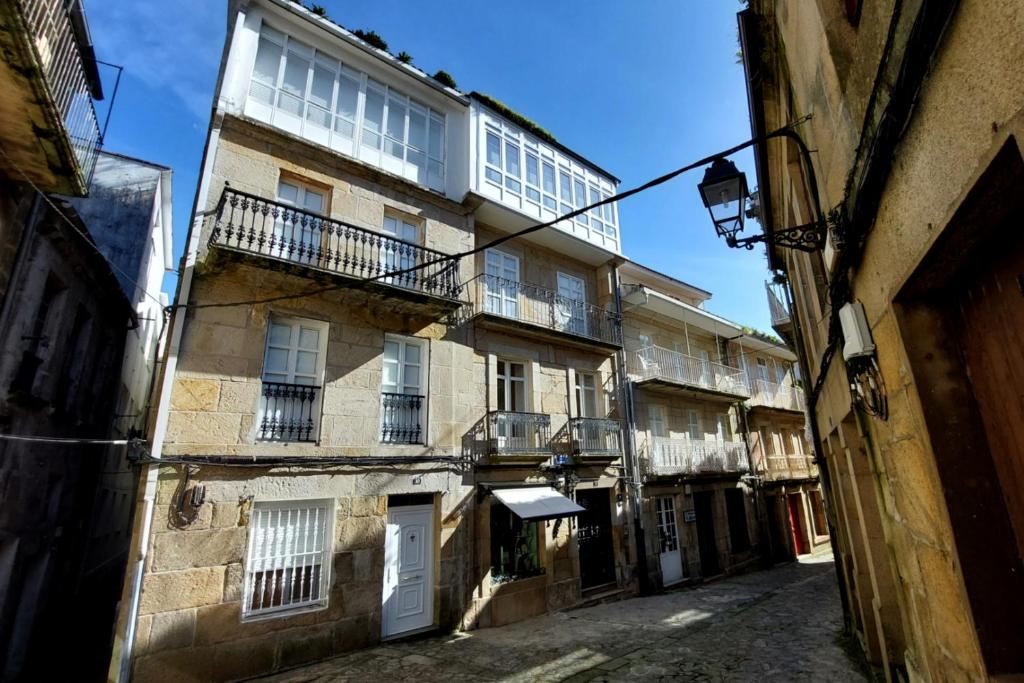 an alley with an old building with a balcony at Casa do jato in Muros