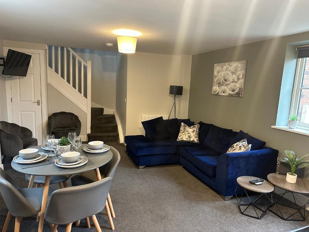 a living room with a blue couch and a table at Maple House by ShortStays4U A beautiful 2Bedroom House with free parking in town centre! in King's Lynn