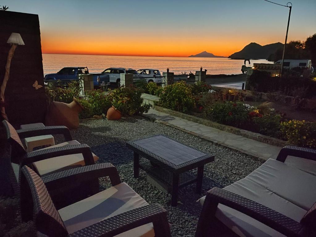 a group of chairs and a table in front of the ocean at liogerma i in Agios Ioannis Kaspaka