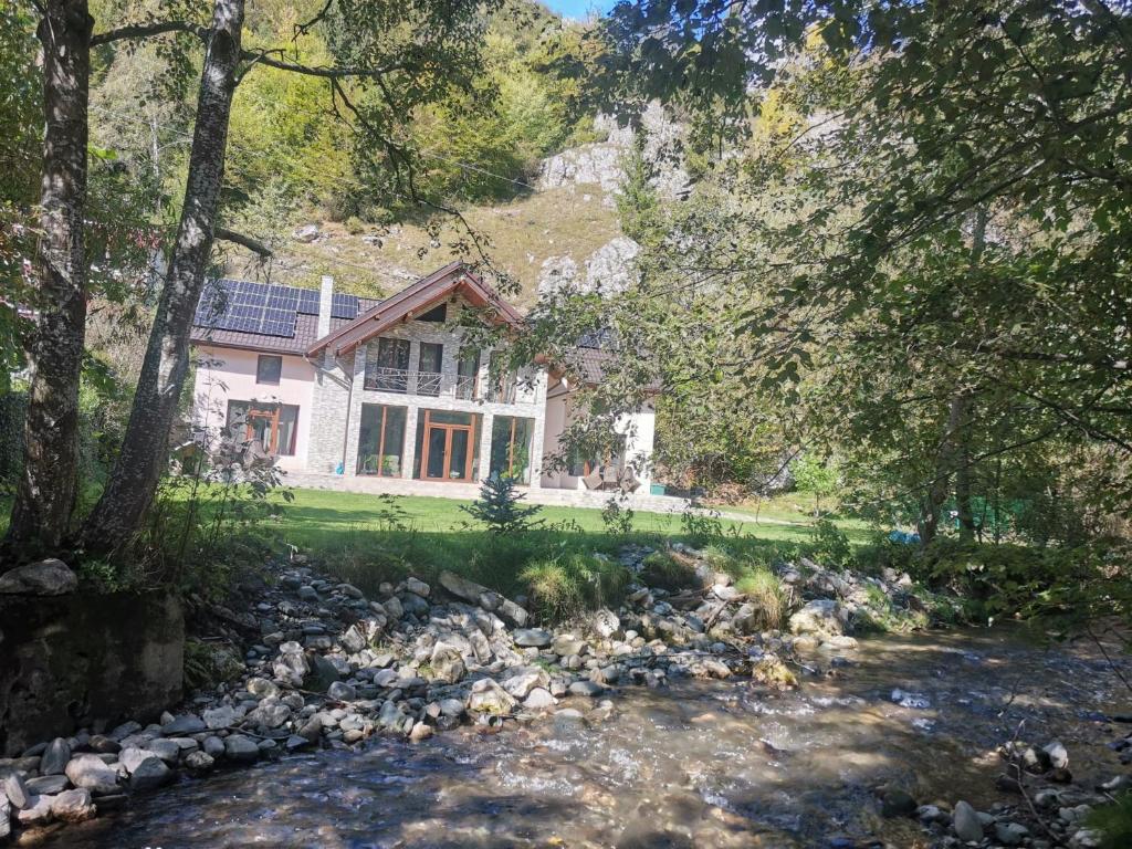 a house with a river in front of it at La Stanca in Cheia