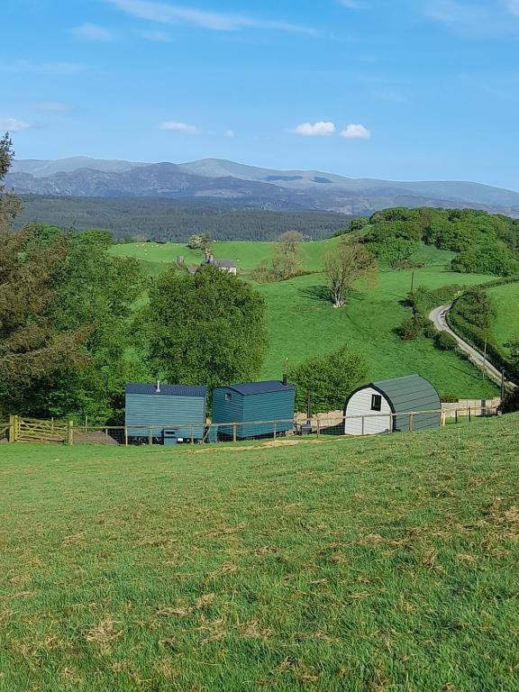 a field with two barns on a hill at Siabod Huts in Betws-y-coed