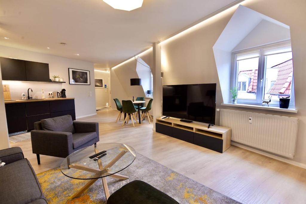a living room with a couch and a tv and a table at Sehr gemütlich und modern in Haldensleben