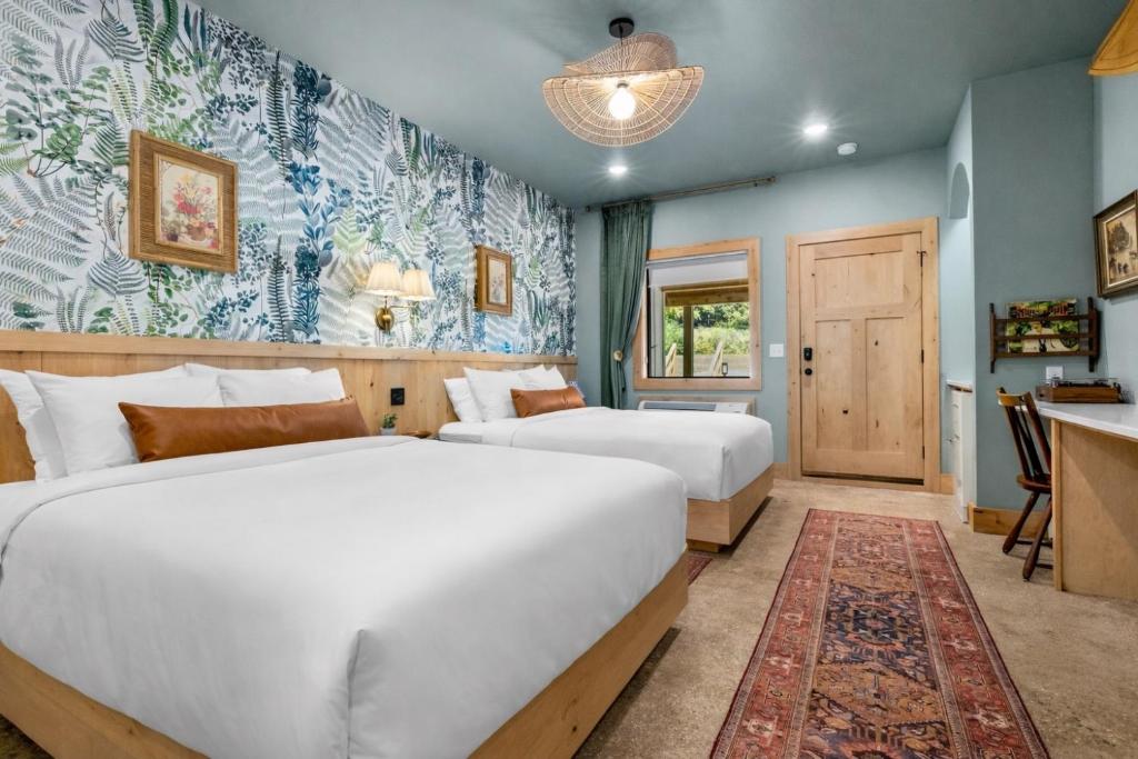 two beds in a room with blue walls at Sommer House Inn-Aloha Room in Jasper