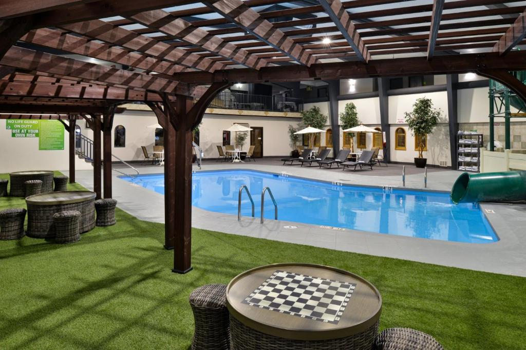 a pool with a checkeredkered table in front of a building at Holiday Inn Great Falls-Convention Center by IHG in Great Falls