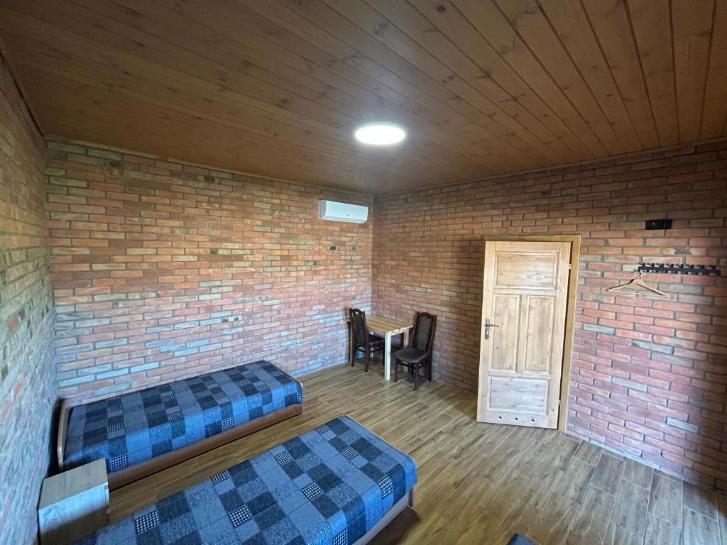 a room with two beds and a brick wall at Hotel Eliot in Łomża