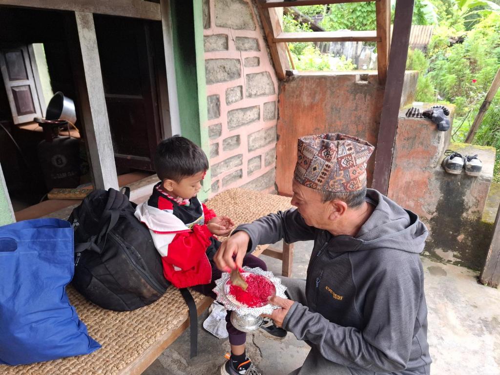 a man and a child sitting at a table with a cake at Sunya Homestay in Kirāntīchhāp