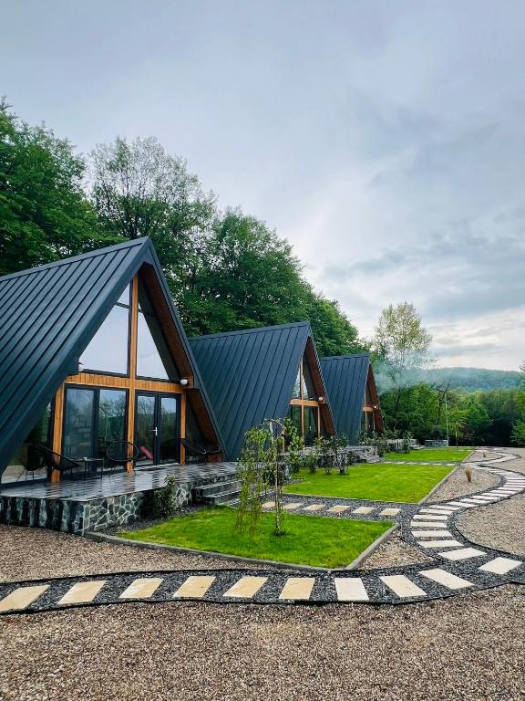a large building with a black roof and a garden at A-frame Marisa Vadu Crisului in Vadu Crişului