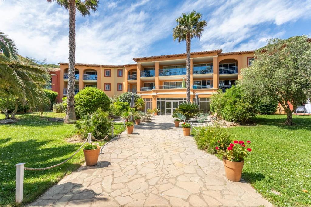 an exterior view of a building with palm trees at Résidence Pierre & Vacances La Pinède in Hyères