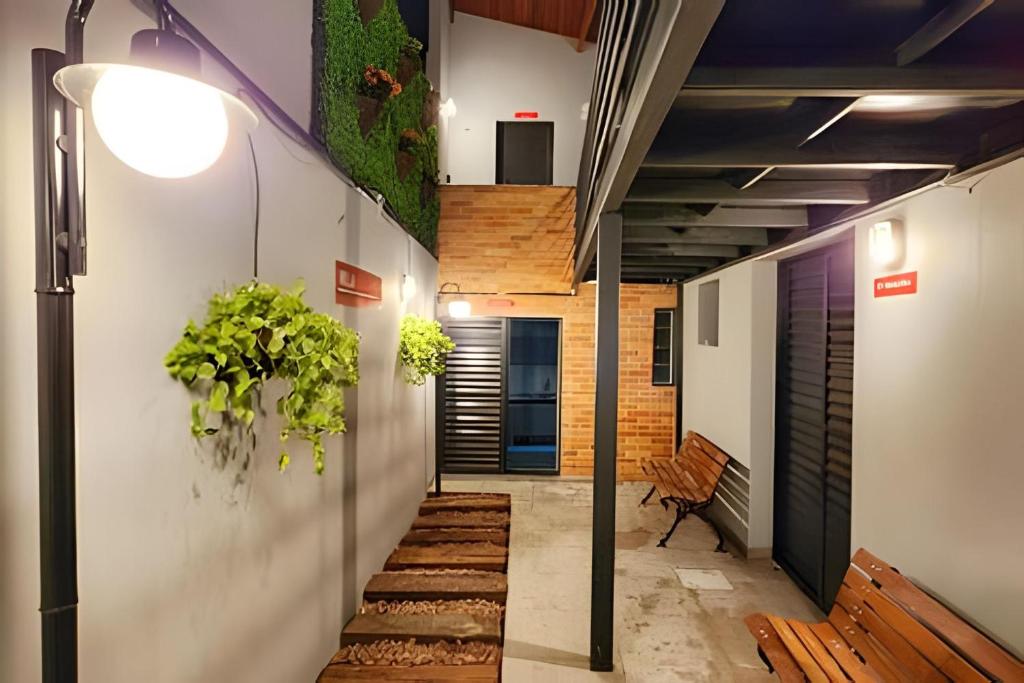a hallway with a bench and plants on the wall at Studio V - Com Ar Condicionado in Jundiaí