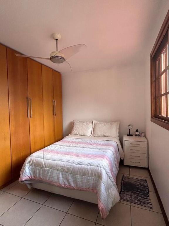 a bedroom with a bed and a ceiling fan at Alugo quarto com internet in Porto Alegre