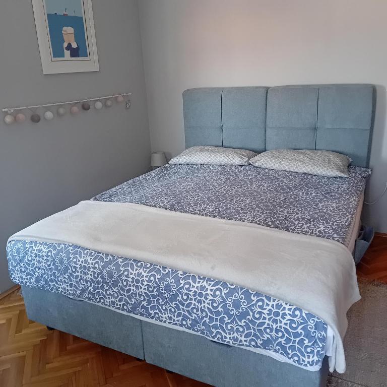 a bed with a blue headboard in a bedroom at Barbara in Bjelovar