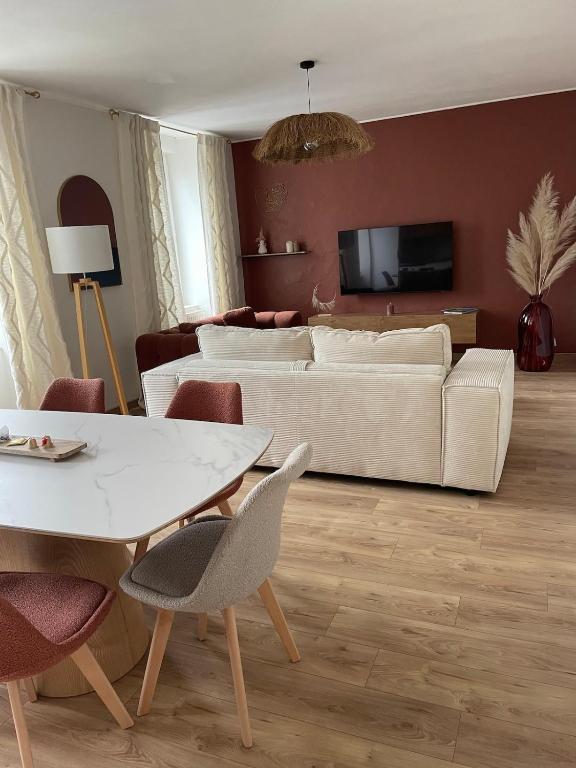 a living room with a white couch and a table at La Mandarouseraie in Millau