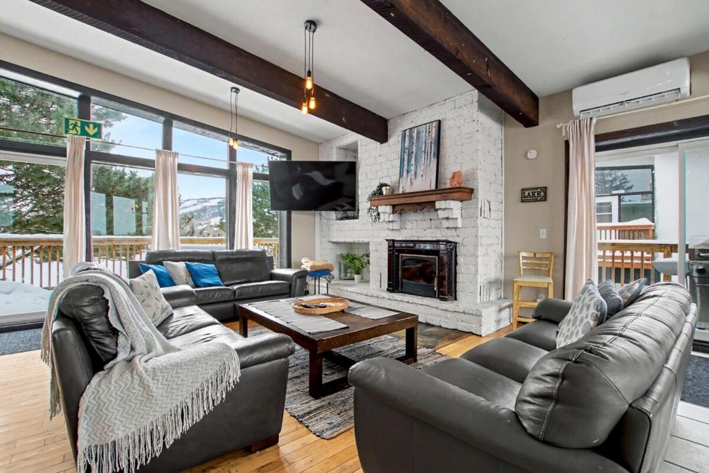 a living room with leather furniture and a fireplace at Northview-Blue Mountain-Sauna-Firepit-Balcony-Parking in Blue Mountains