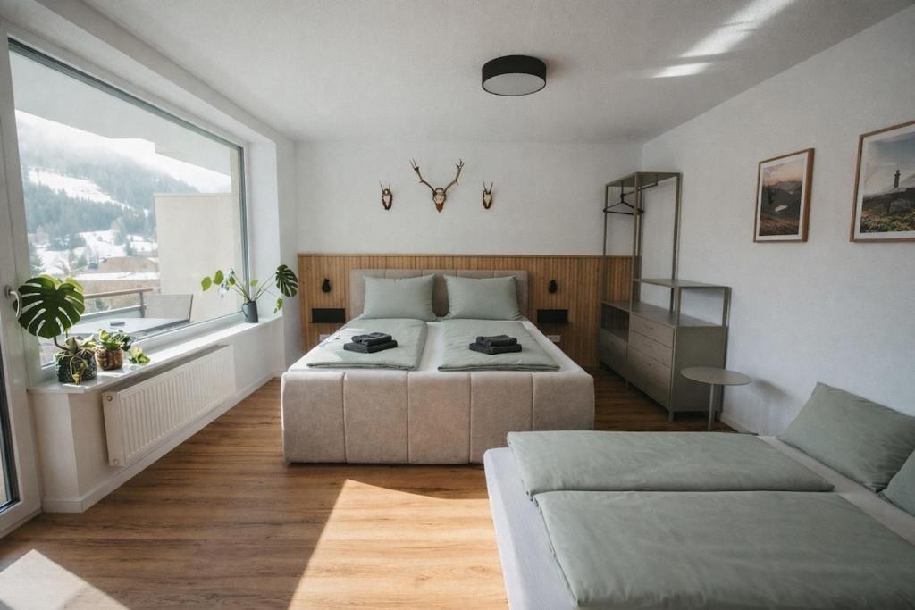 a bedroom with a bed and a large window at Schwarzwald Loft Bergblick in St. Blasien
