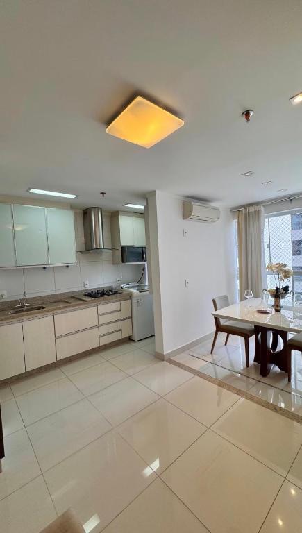 a kitchen with a table and a dining room at Metropolitan Mall in Goiânia